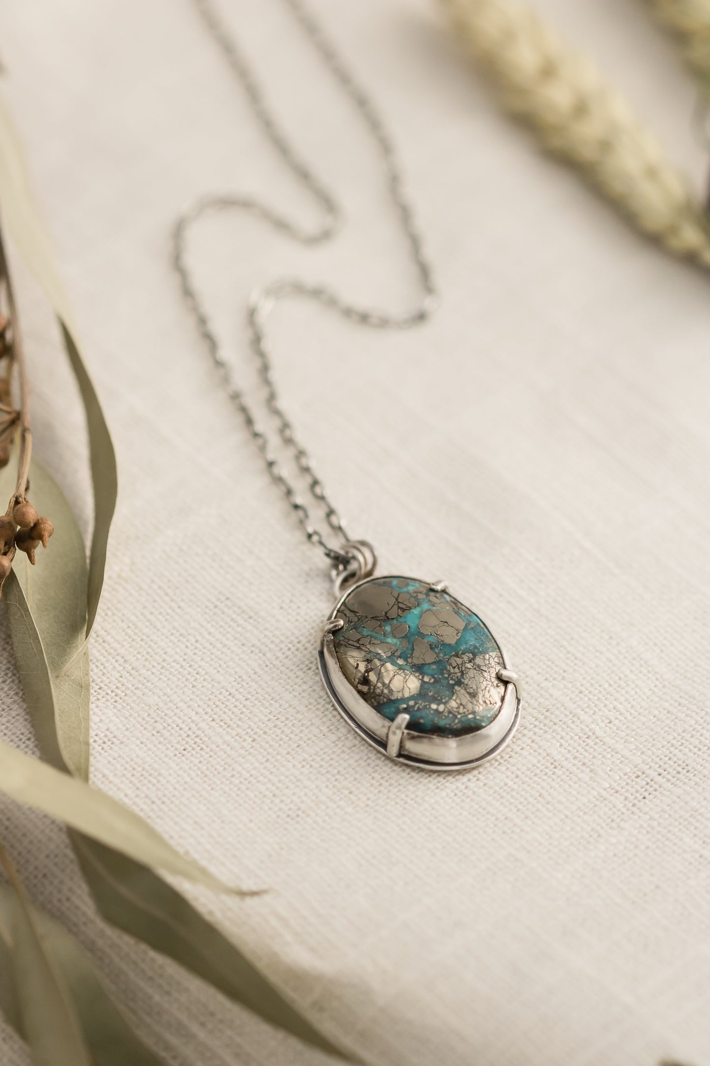 Morenci II turquoise pendant necklace on linen background with dried flowers