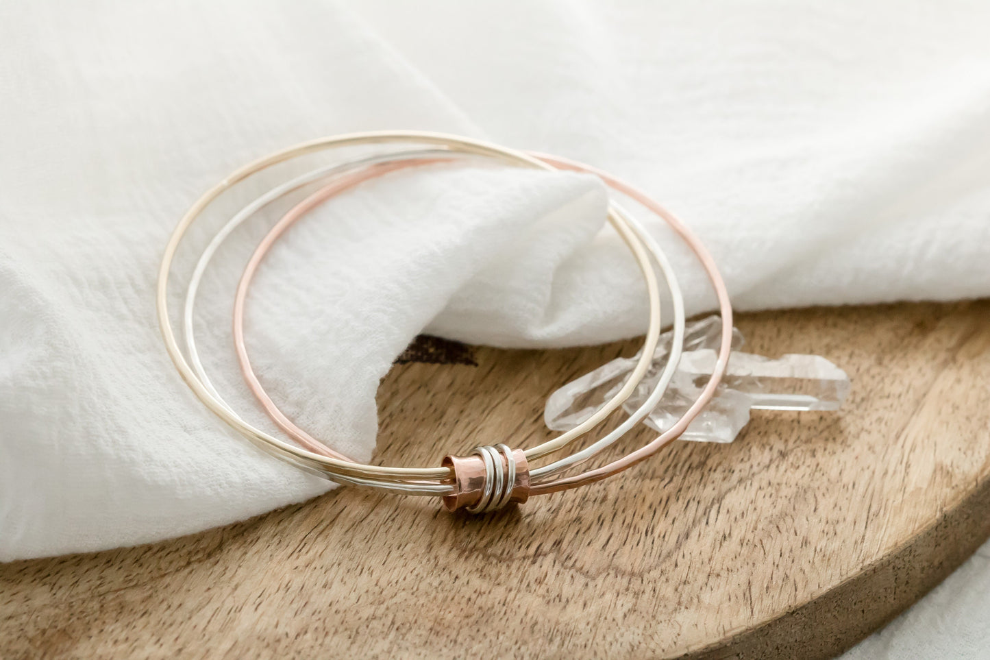 Three mixed metal bangles of sterling silver, 14K gold filled and copper with a copper spinner bead with sterling silver rings.