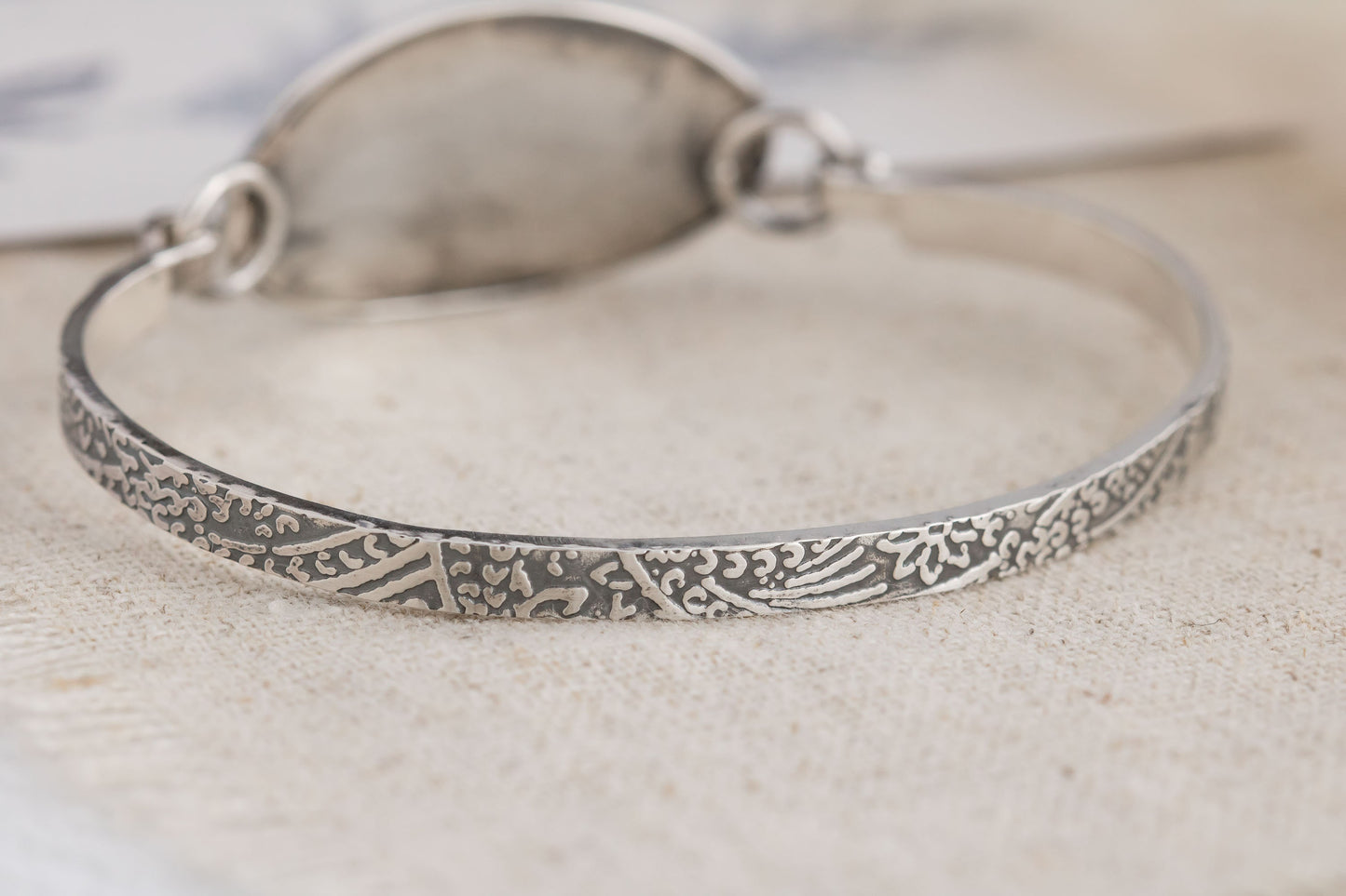 Handmade sterling silver wildflower tension cuff bracelet, crafted in Soldotna, Alaska, featuring a textured band and floral design