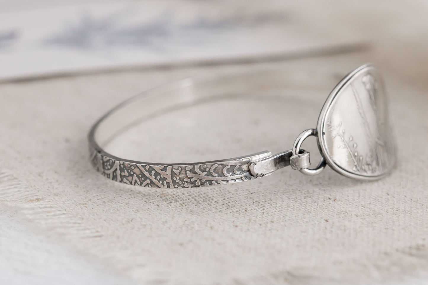 Handmade sterling silver wildflower tension cuff bracelet, crafted in Soldotna, Alaska, featuring a textured band and floral design.