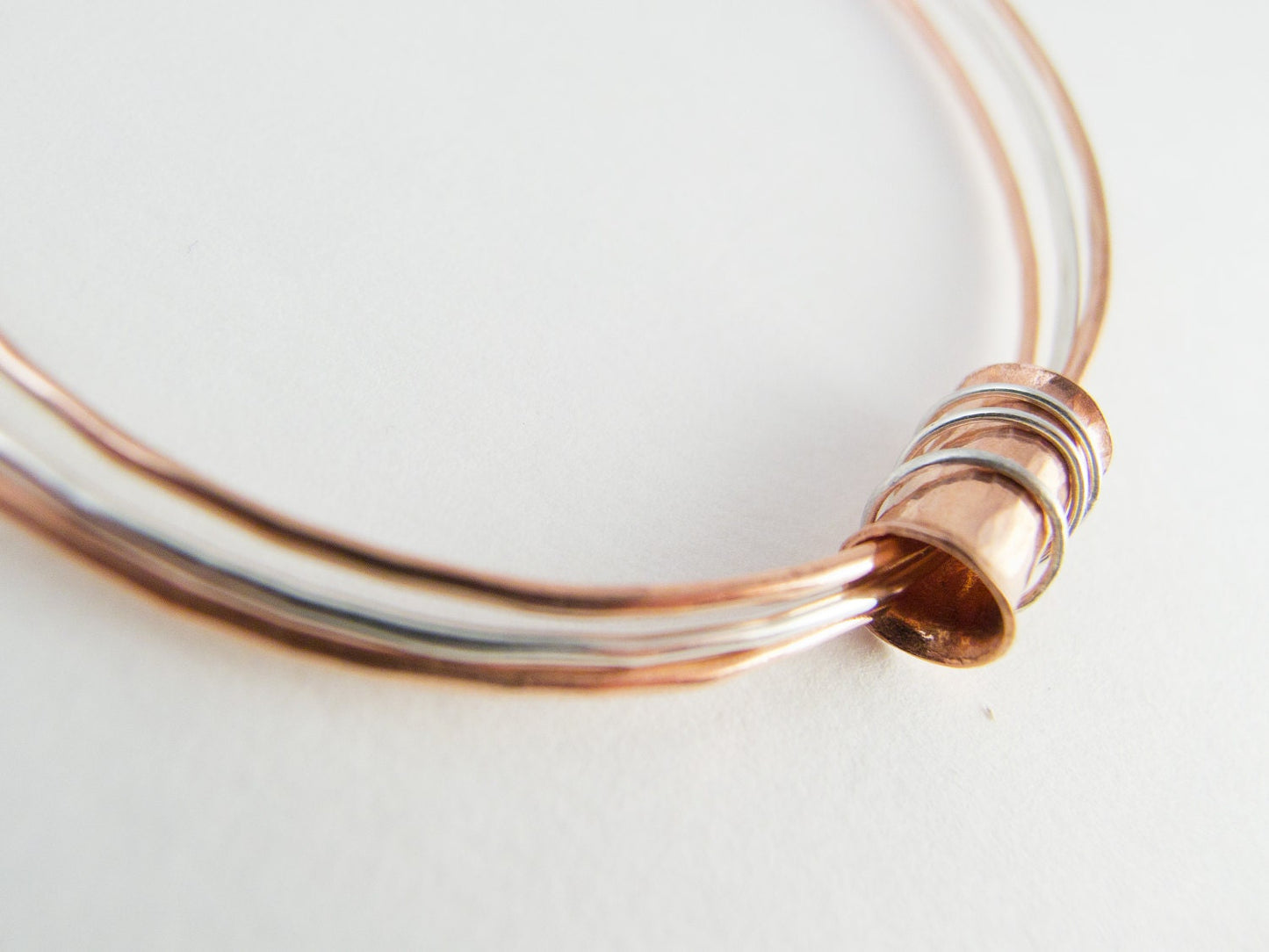 Three mixed metal bangles of sterling silver, 14K gold filled and copper with a copper spinner bead with sterling silver rings.