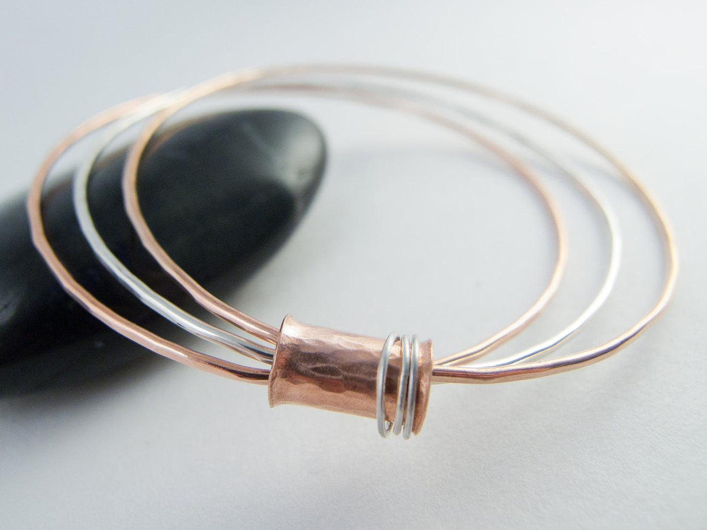 Three mixed metal bangles of sterling silver, 14K gold filled and copper with a copper spinner bead with sterling silver rings.