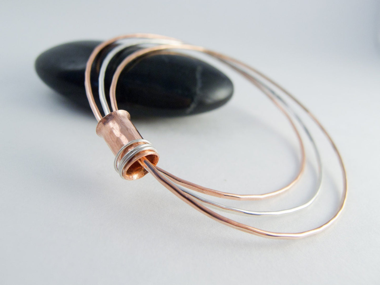Three mixed metal bangles of sterling silver, 14K gold filled and copper with a copper spinner bead with sterling silver rings.