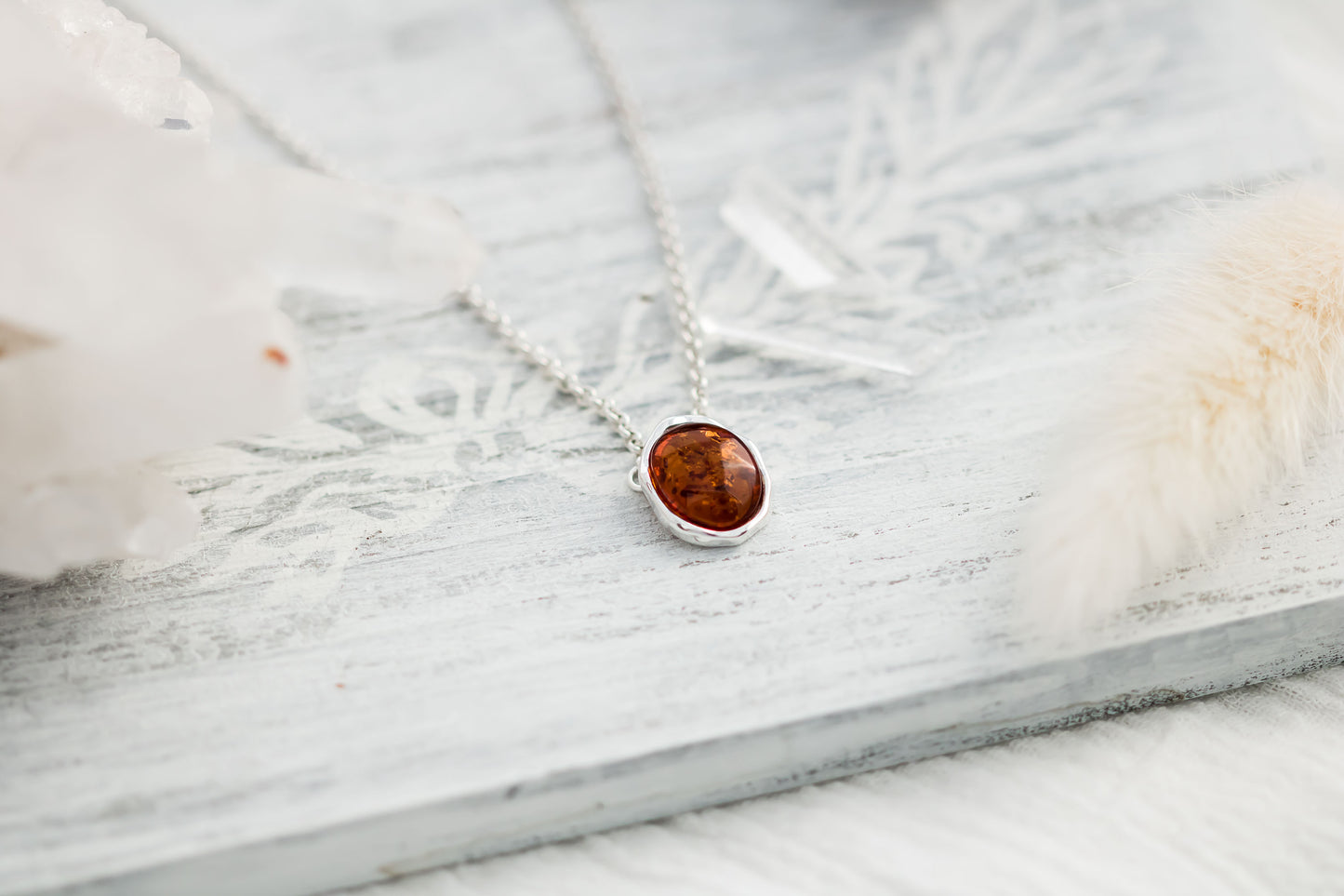 Baltic Amber oval cabochon pendant in a hammered sterling silver bezel setting on a sterling silver 18 inch with 2 inch extender rolo chain.