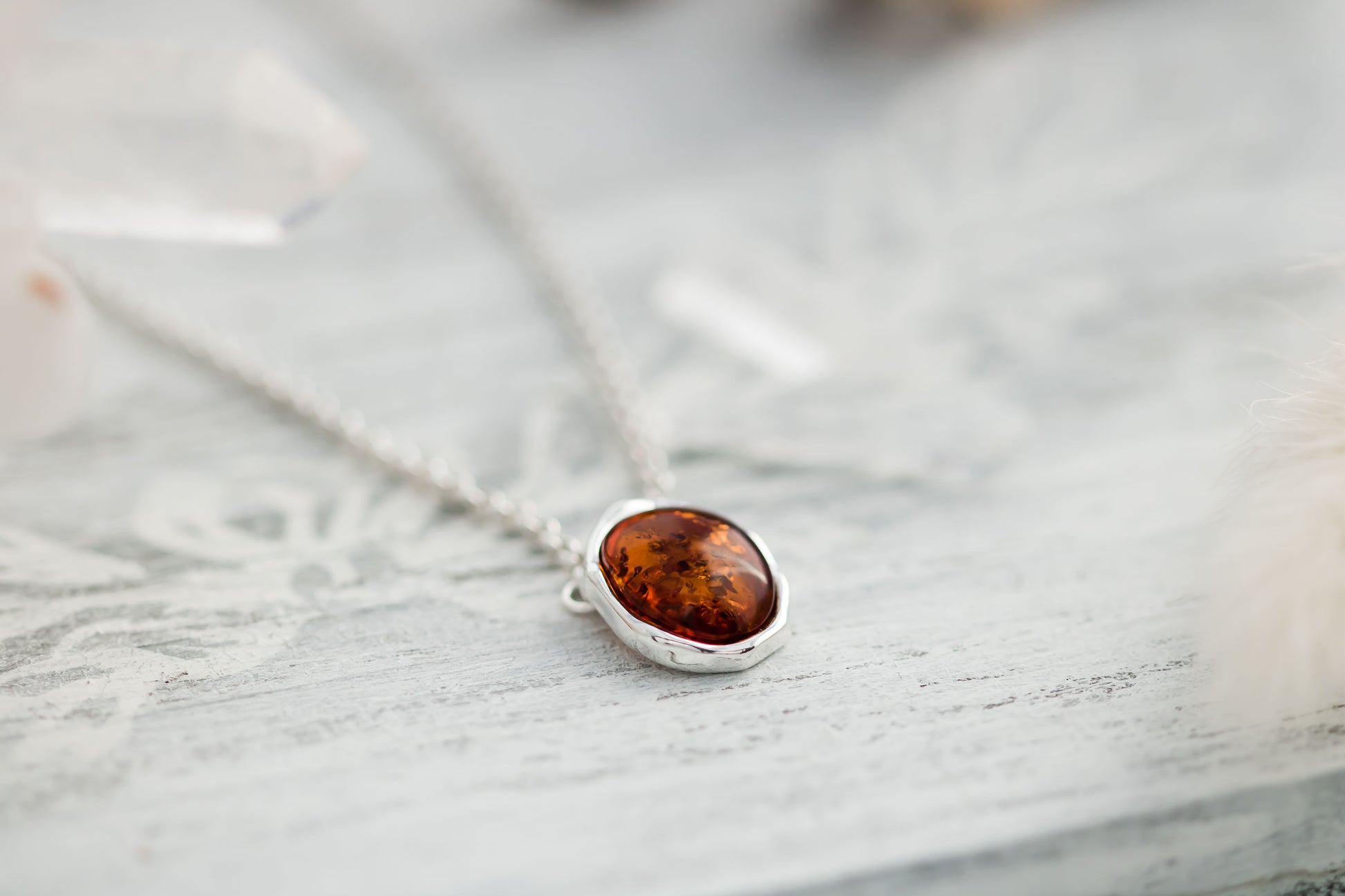 Baltic Amber oval cabochon pendant in a hammered sterling silver bezel setting on a sterling silver 18 inch with 2 inch extender rolo chain.