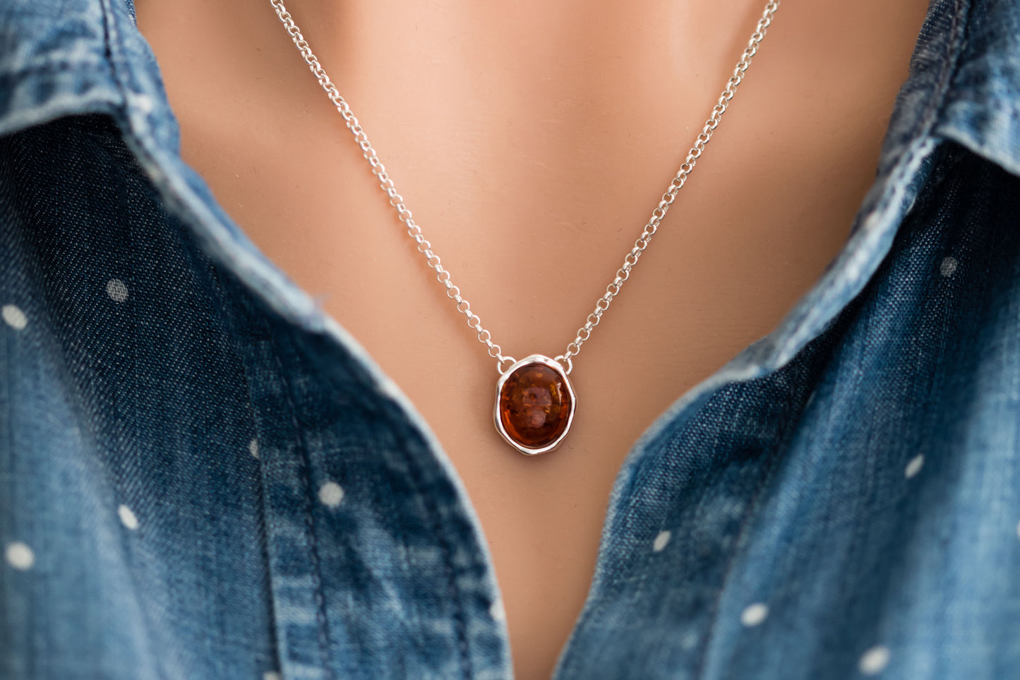 Baltic Amber oval cabochon pendant in a hammered sterling silver bezel setting on a sterling silver rolo chain.