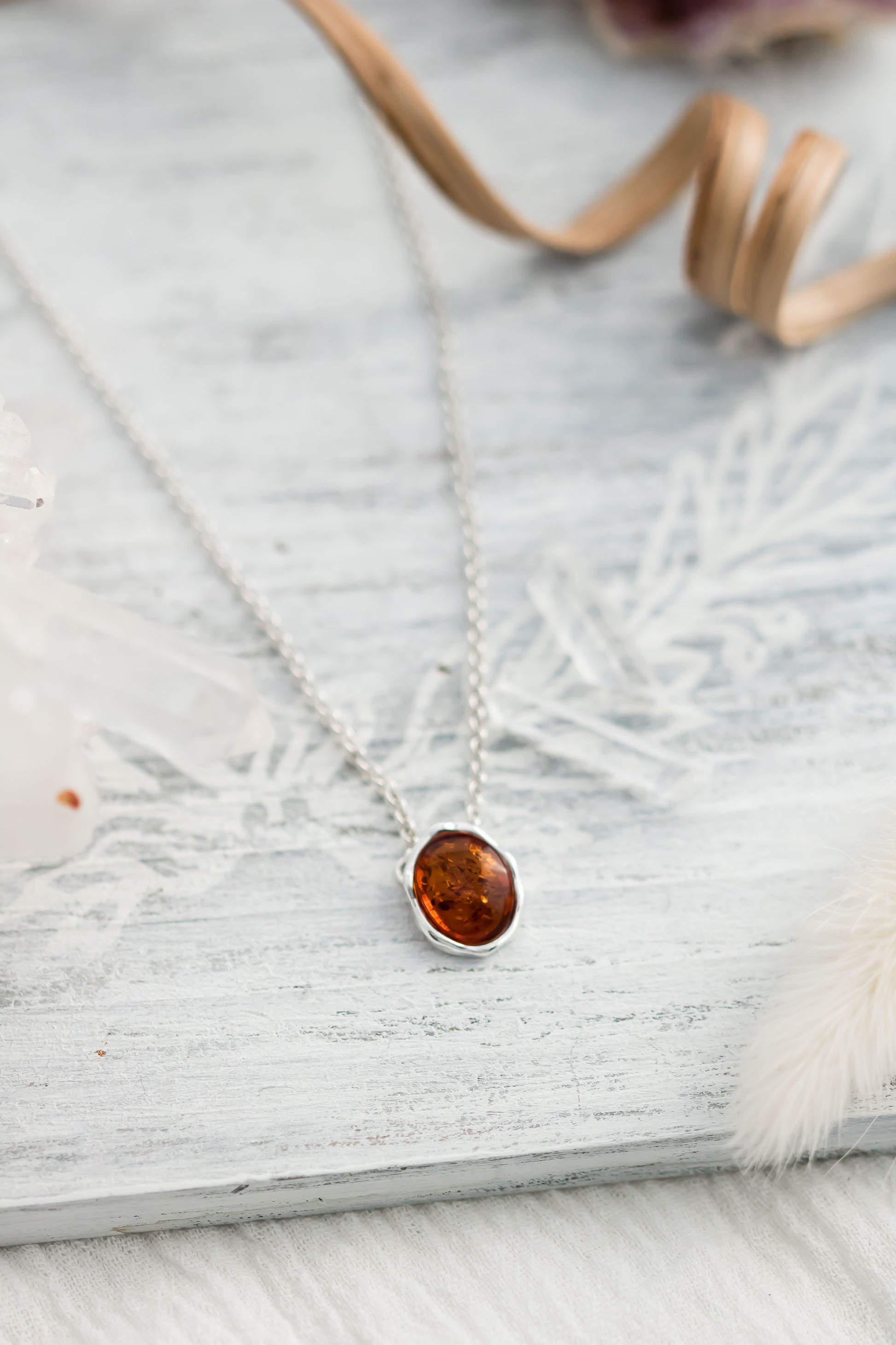 Baltic Amber oval cabochon pendant in a hammered sterling silver bezel setting on a sterling silver 18 inch with 2 inch extender rolo chain.