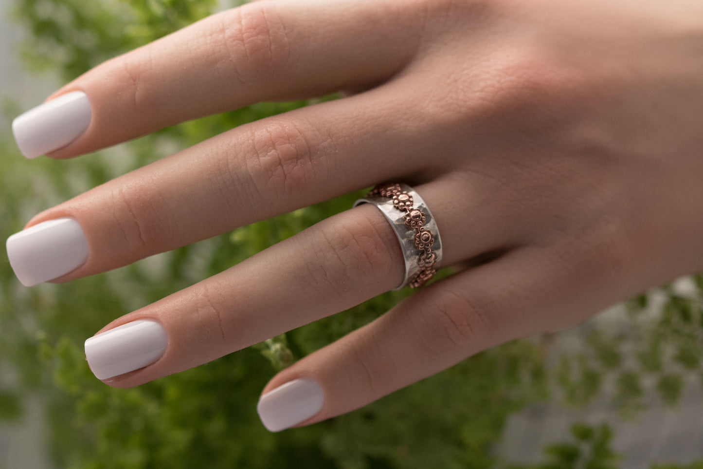 Sterling silver ring band with outer daisy flower copper ring band that spins freely.