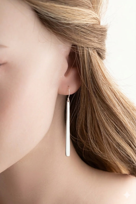 Close-up of a person wearing a silver earring with a soft background