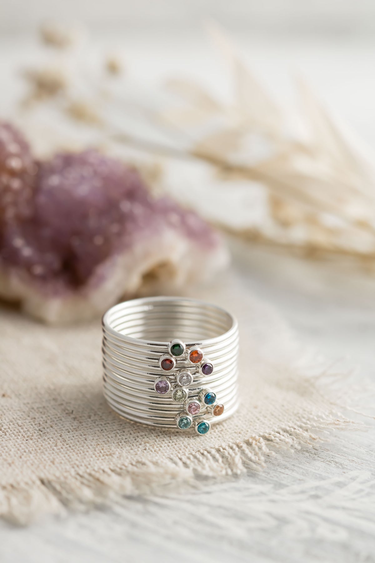 Sterling silver stacking rings with colorful cubic zirconia birthstones showcasing birthstone options.
