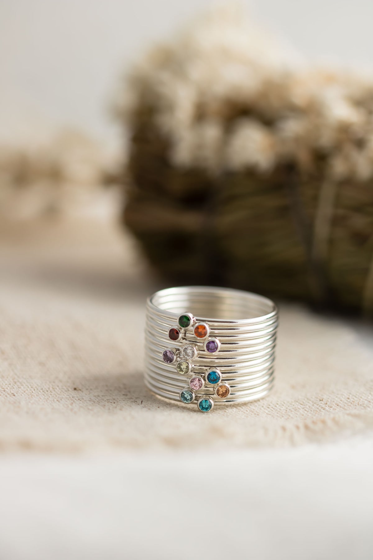 Sterling silver stacking rings with colorful cubic zirconia birthstones showcasing birthstone options.
