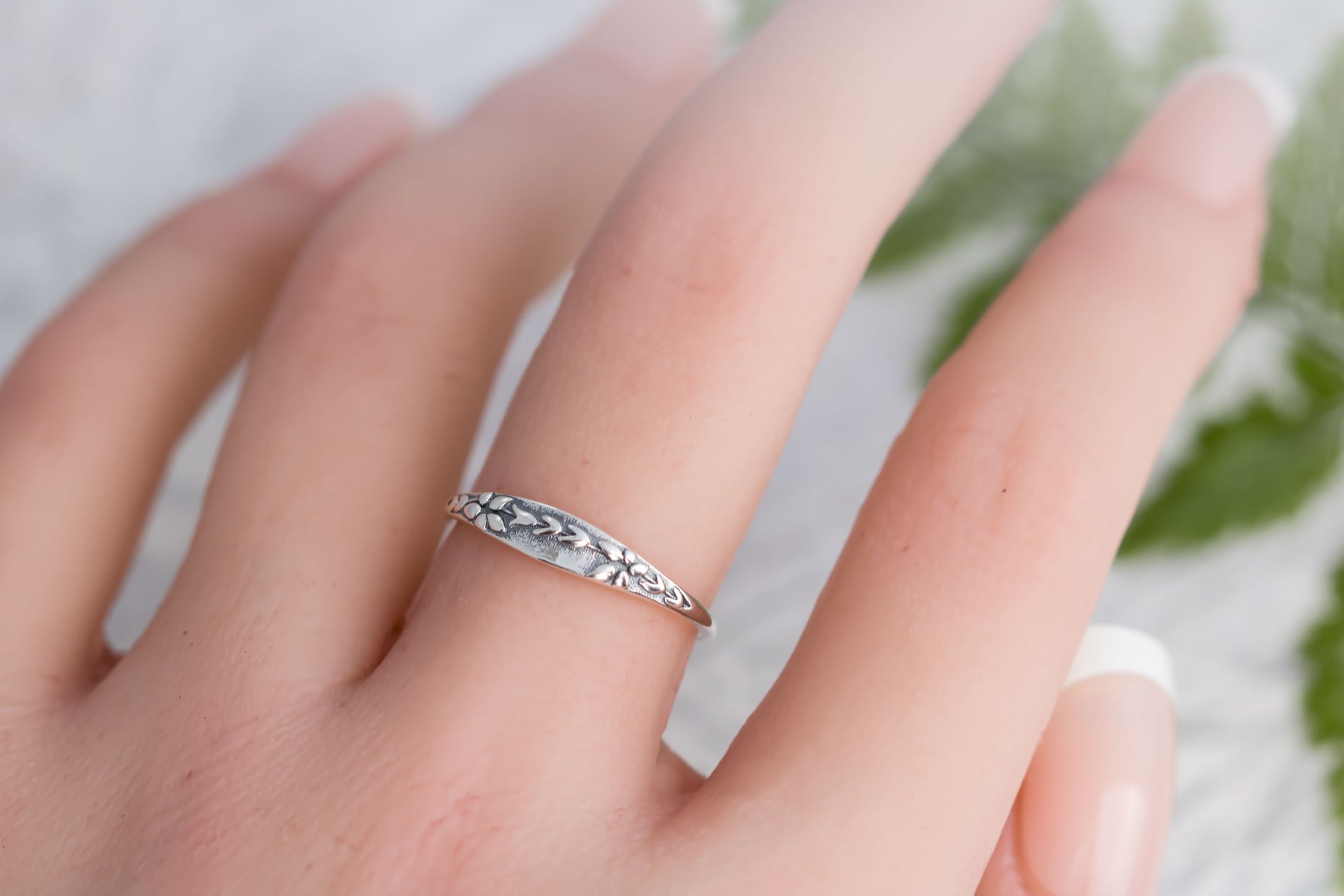 Narrow sterling silver ring with wildflower tapestry impression. 