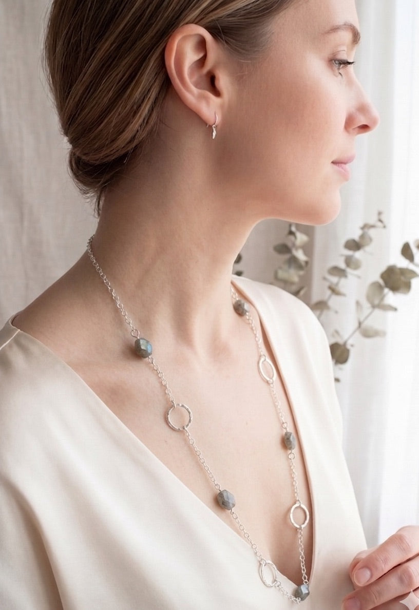 Woman wearing a 35 inch sterling silver and labradorite necklace with hand made silver circle links and faceted labradorite nuggets.