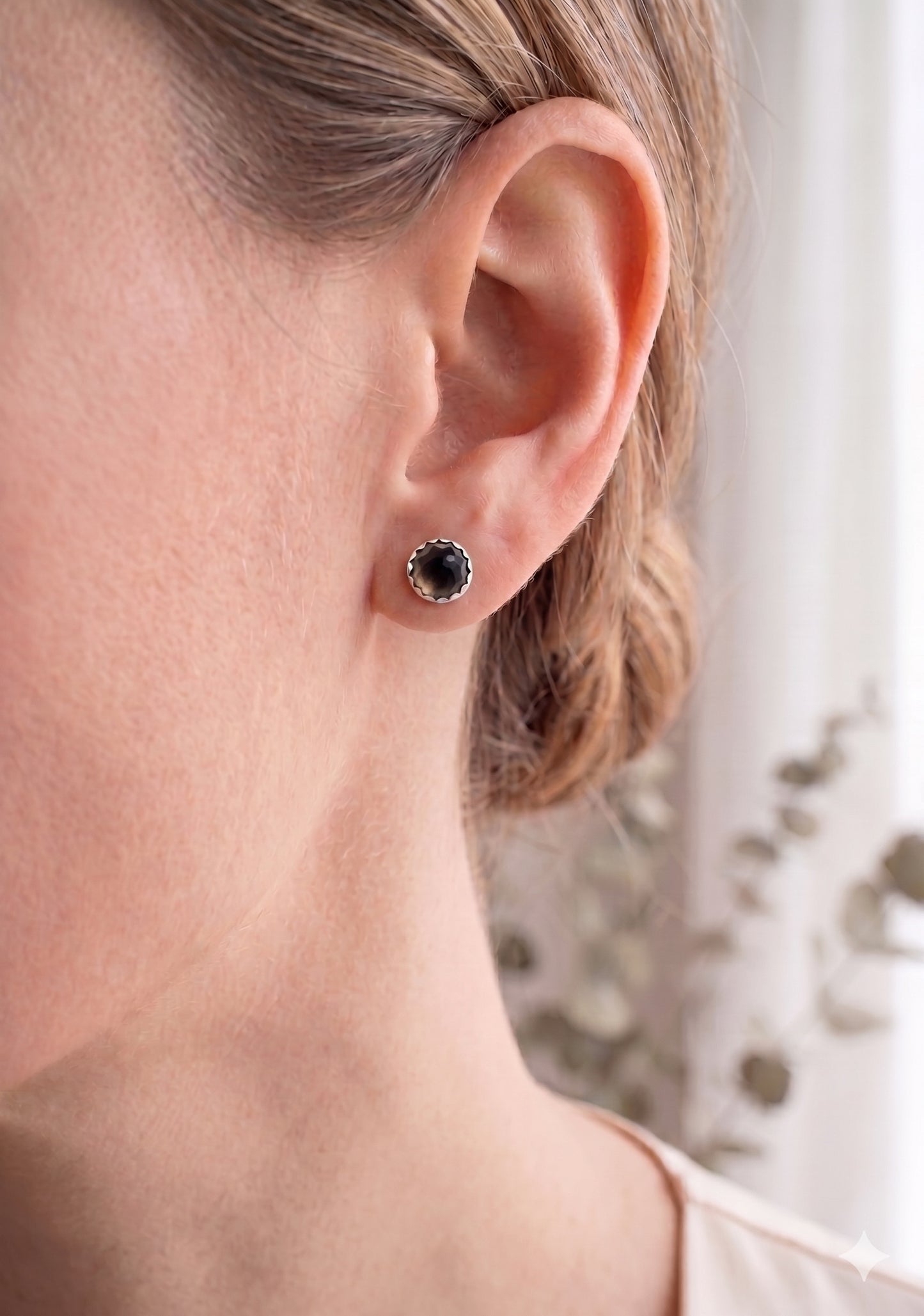 Smokey Quartz and sterling silver earrings on a model. 