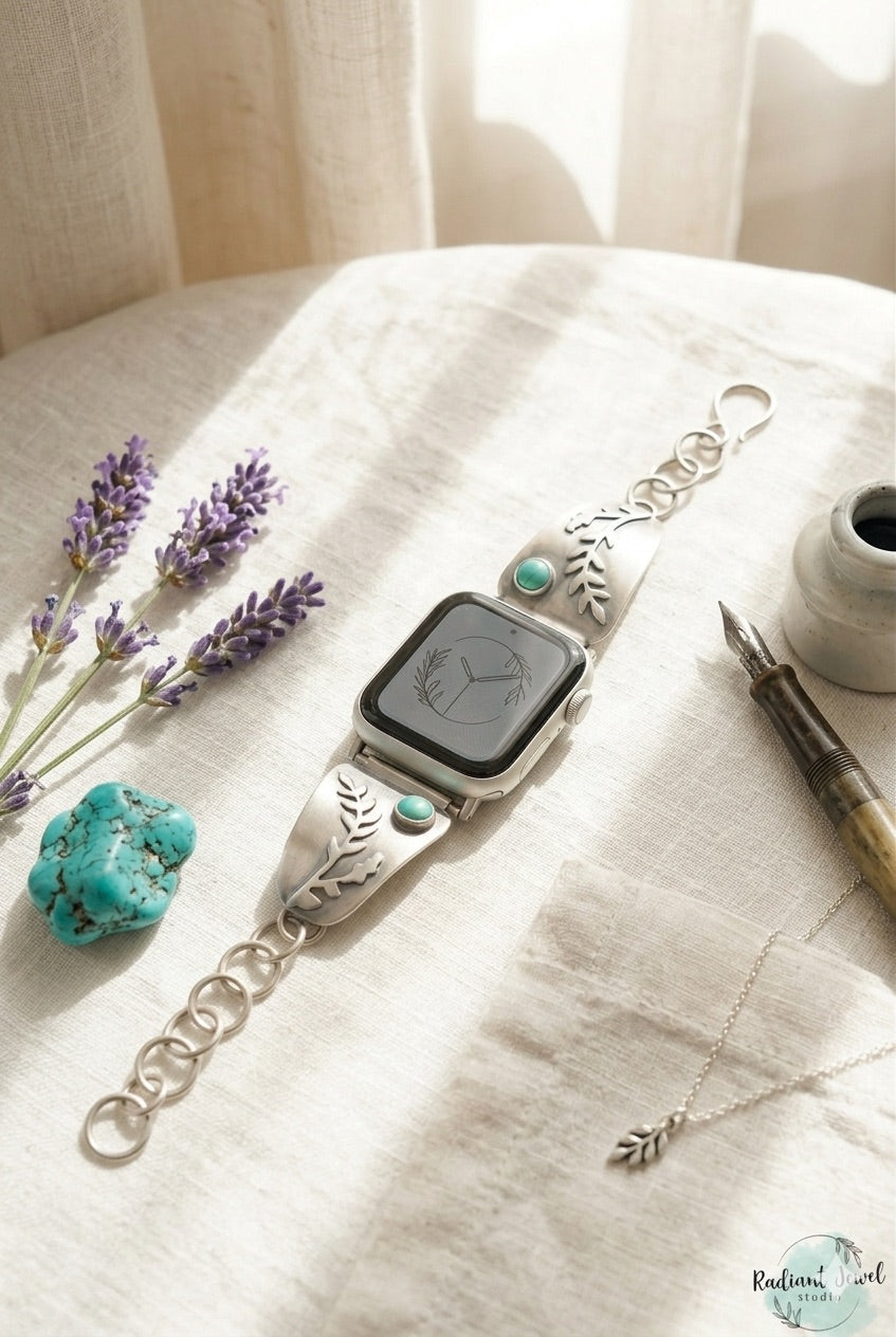 Sterling Silver smartwatch with decorative fern design and turquoise stone on a marble surface with flowers and turquoise stones