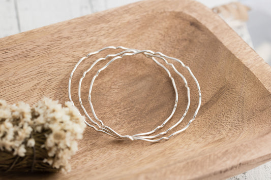 Set of three sterling silver stacking wavy bangle bracelets.