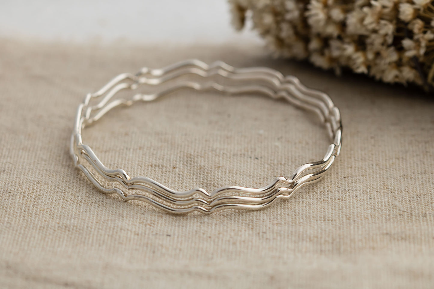 Set of three sterling silver stacking wavy bangle bracelets.