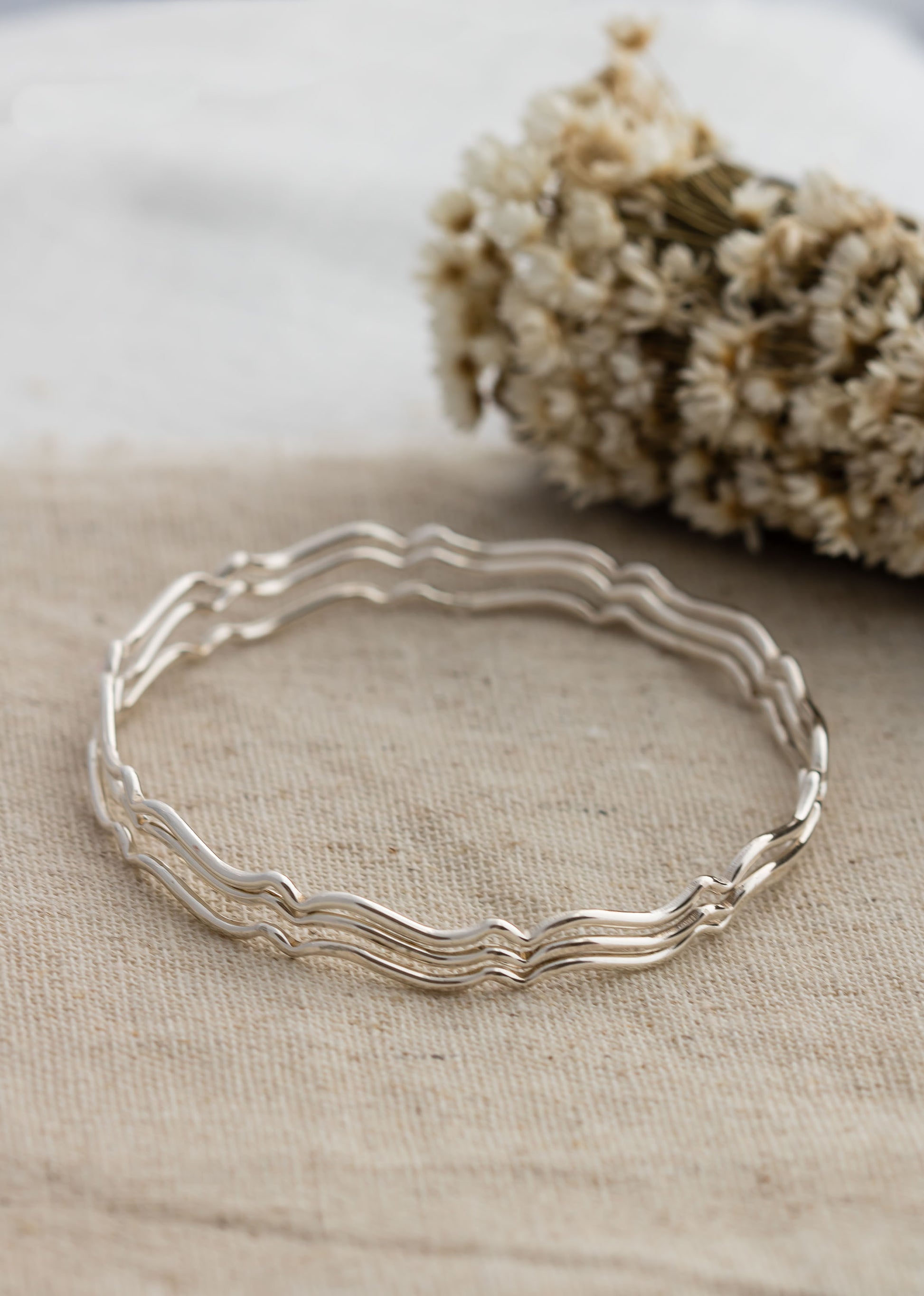 Set of three sterling silver stacking wavy bangle bracelets.