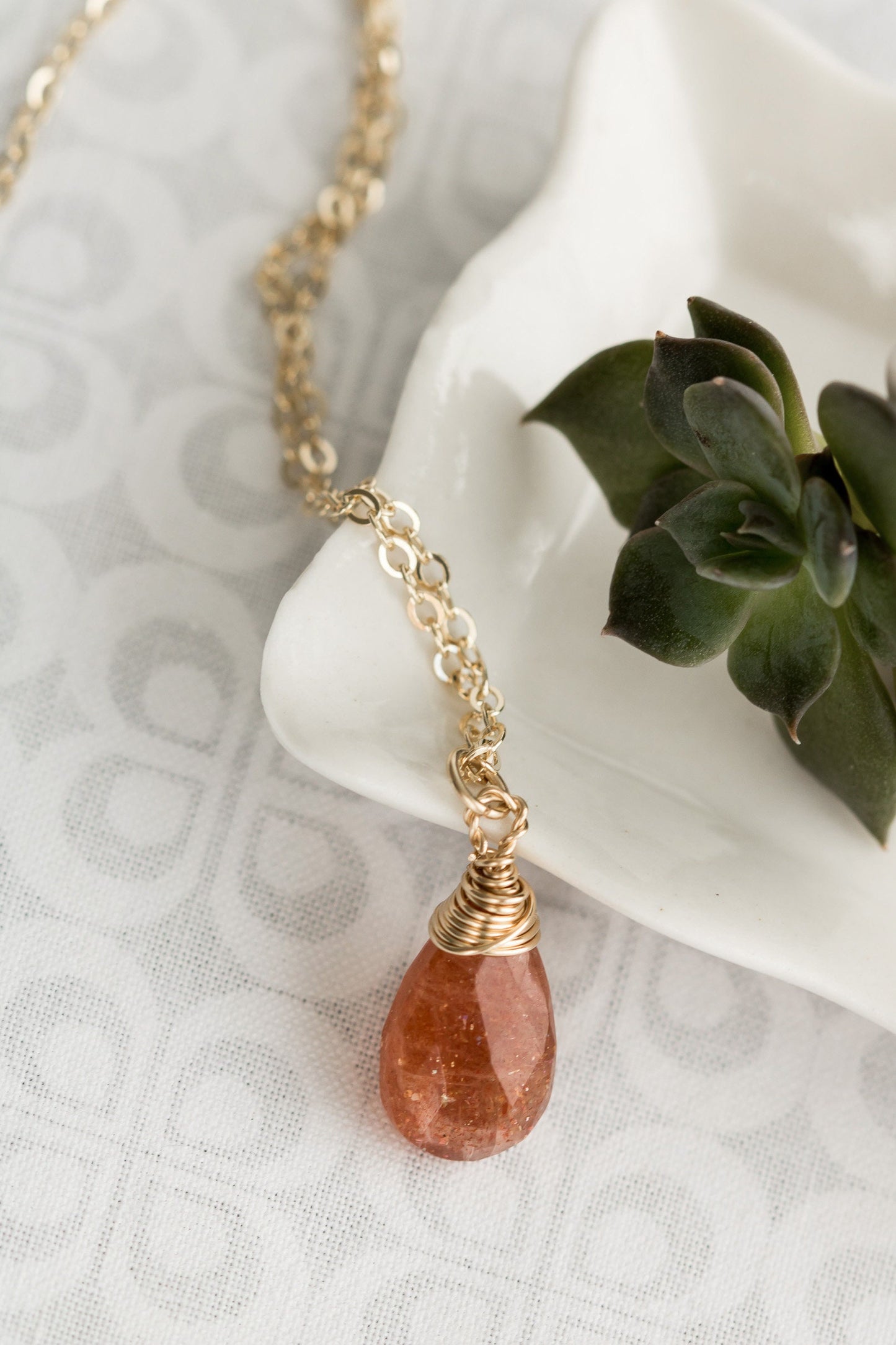 Sunstone pear shaped faceted, briolette wire wrapped in gold filled wire, hanging from gold filled chain.