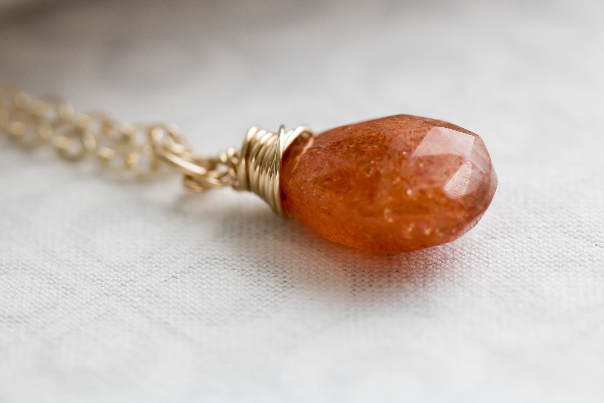 Sunstone pear shaped faceted, briolette wire wrapped in gold filled wire, hanging from gold filled chain.