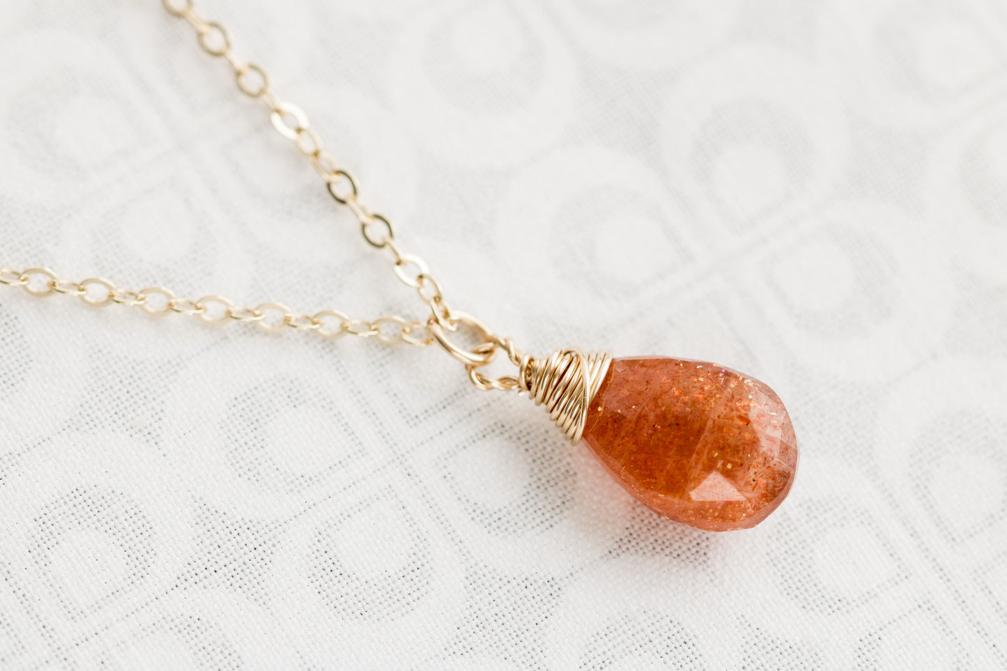 Sunstone pear shaped faceted, briolette wire wrapped in gold filled wire, hanging from gold filled chain.