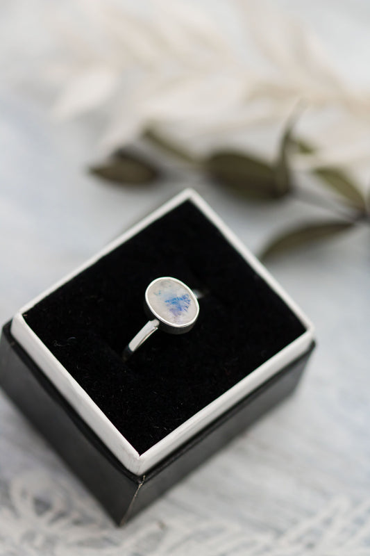 Sterling silver ring with oval faceted moonstone set in a bezel setting with simple silver ring band. 