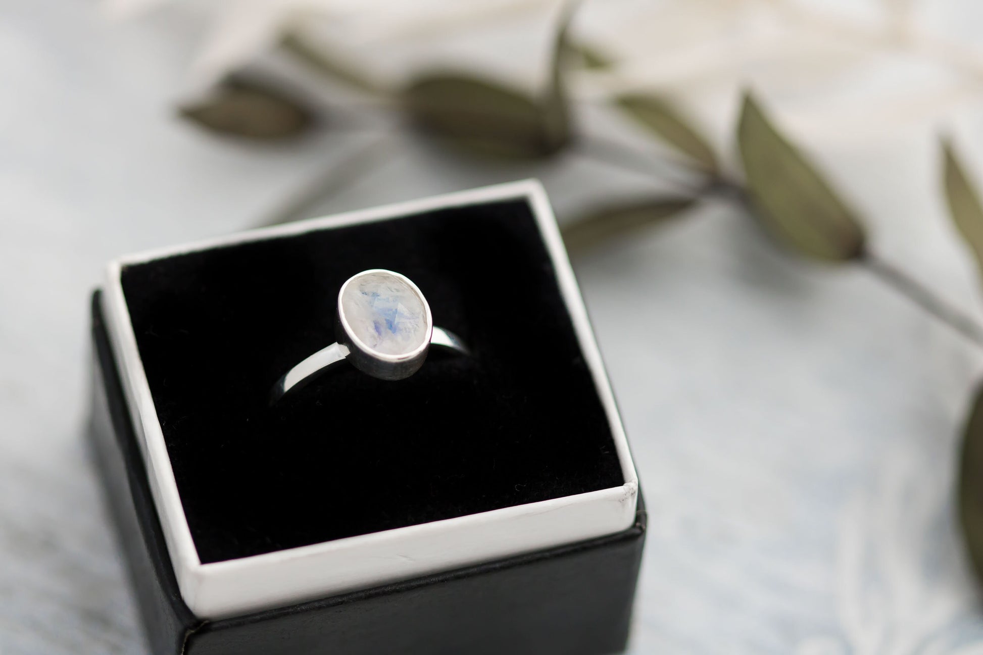 Sterling silver ring with oval faceted moonstone set in a bezel setting with simple silver ring band. 